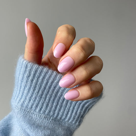 Womans hand with Candy Claws press-on nails in a semi-sheer lilac haze with a pink-lavender undertone