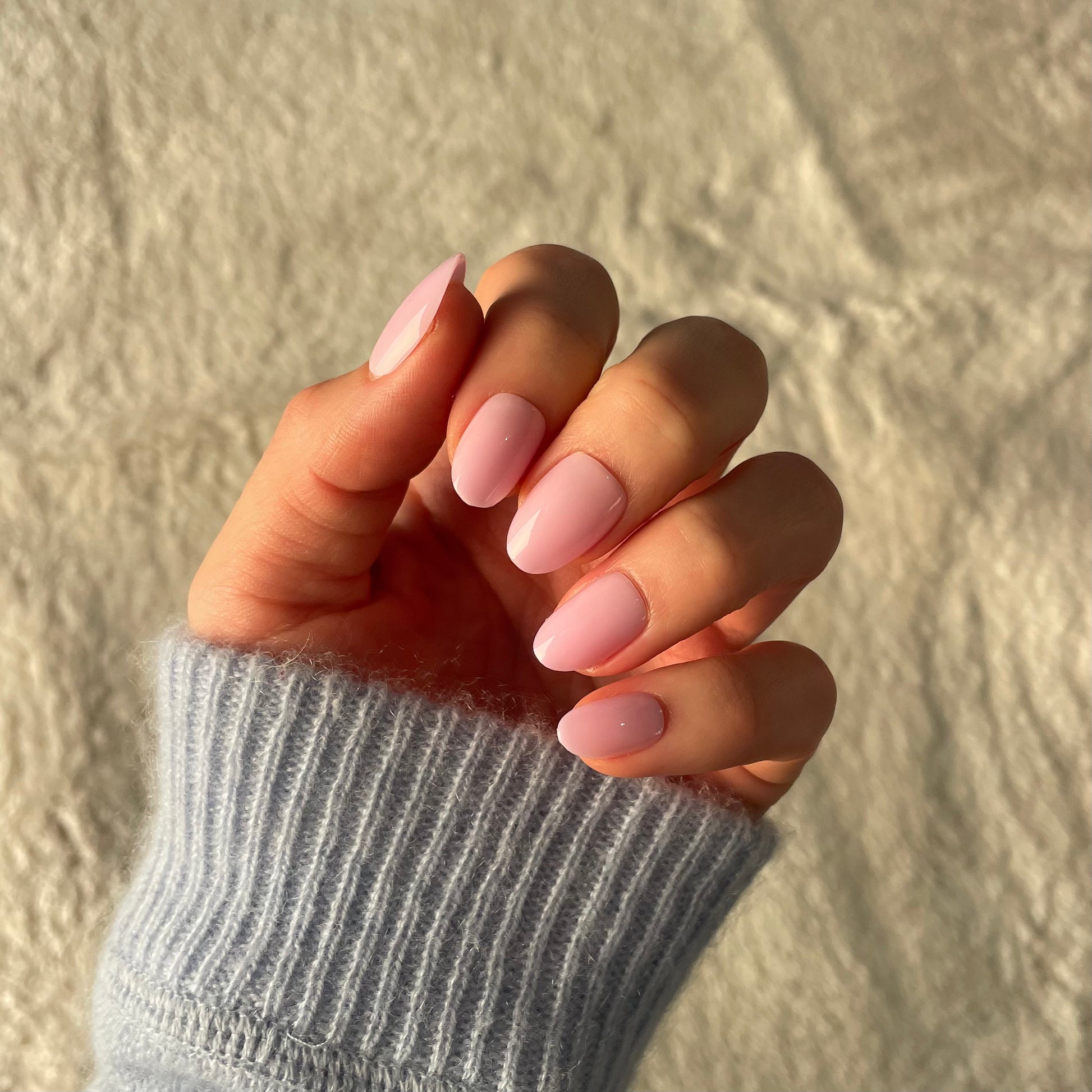 Womans hand with Candy Claws false acrylic nails in a semi-sheer lilac with a pink-lavender undertone