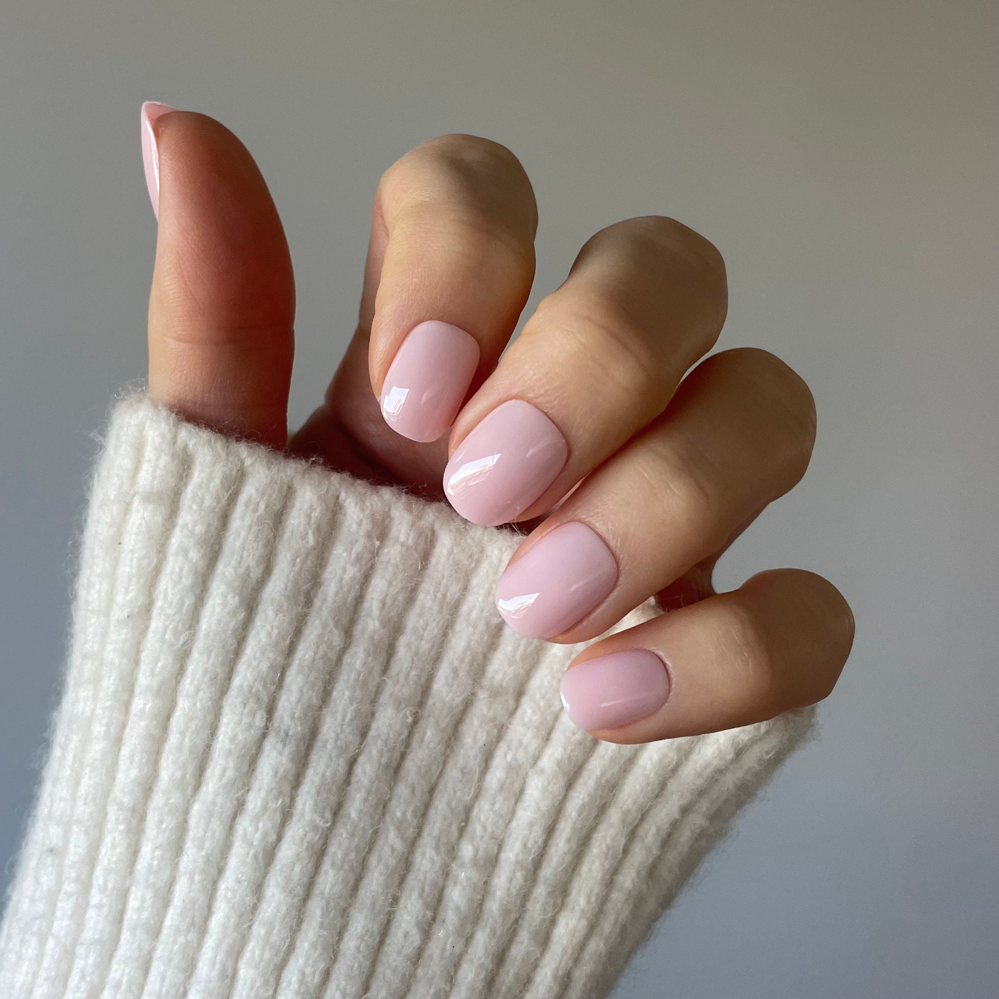 Womans hand with the palest pink removable and reusable professional salon quallity Candy Claws in pillow talk extra-short style