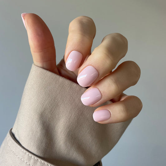 Womans hand with Candy Claws pillow talk press-on acrylic nails in the palest pink extra-short style