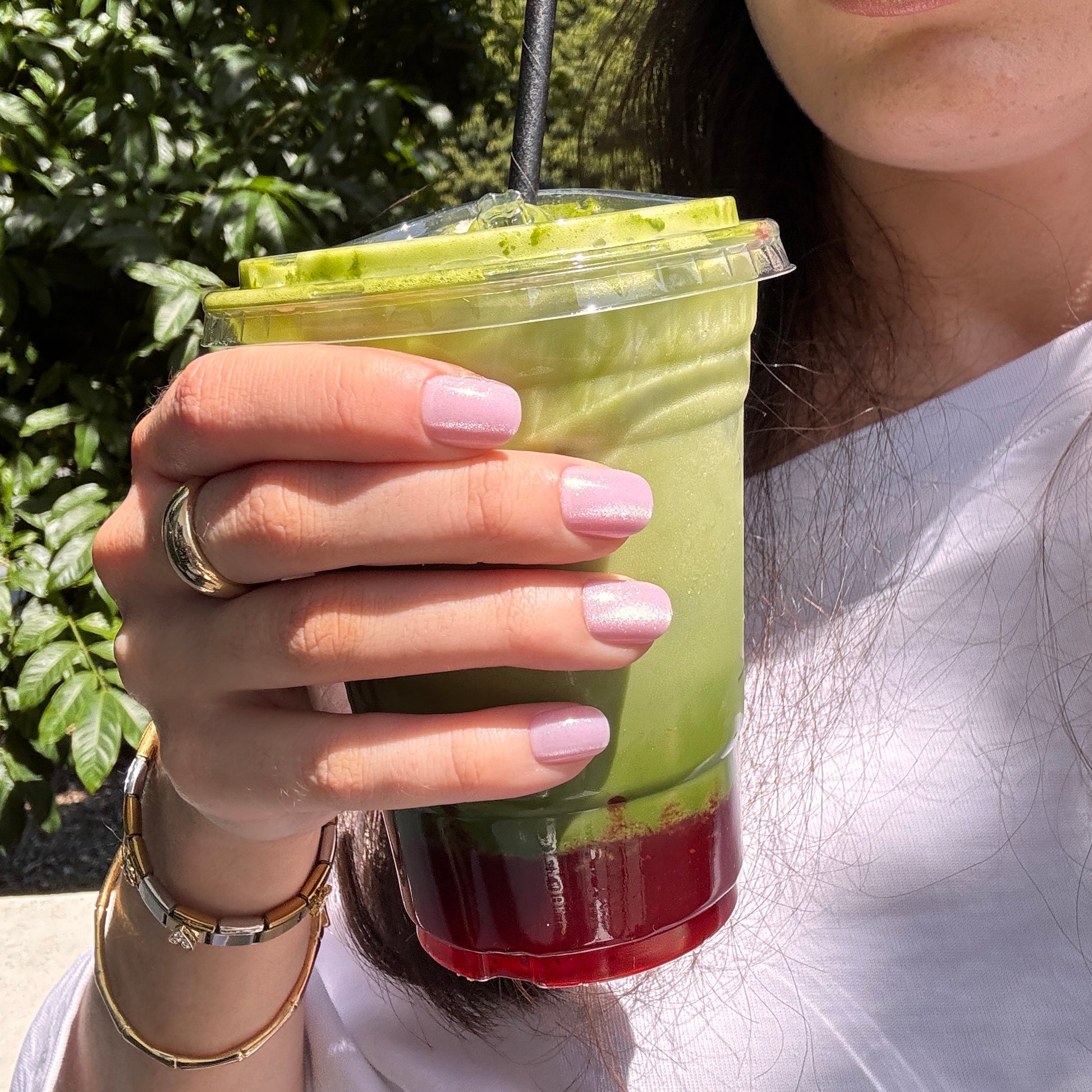 Hand holding a smoothie with Candy Claws press on acrylic nails in shell shocked pink. Reusable and non-damaging.