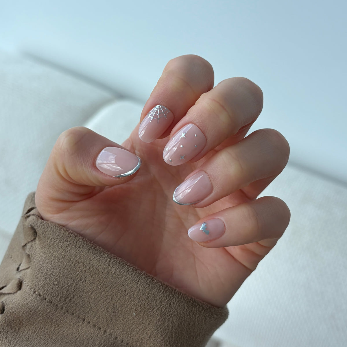 Candy Claws Press-On 100% Acrylic Nails in Short Oval Style. Nocturnal Short Oval nails are light pink with 3d Silver Halloween themed nail art.