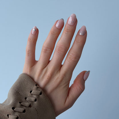 Salon quality reusable Candy Claws Press-On Nails in Short Oval Style. Light pink with 3d Silver Halloween-themed Nail Art featuring cobwebs, silver nail tip and stars. 