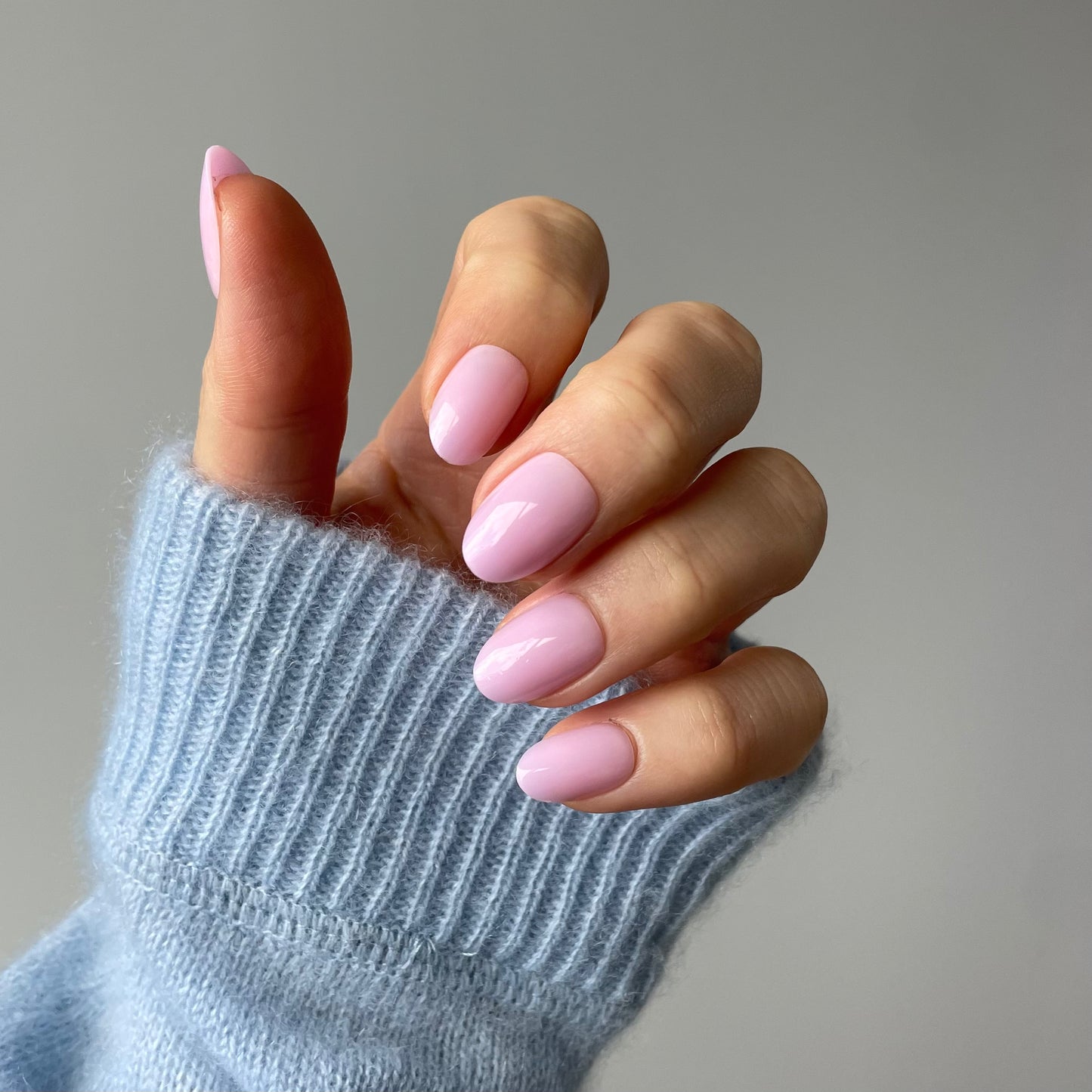 Womans hand with Candy Claws press-on nails in a semi-sheer lilac haze with a pink-lavender undertone