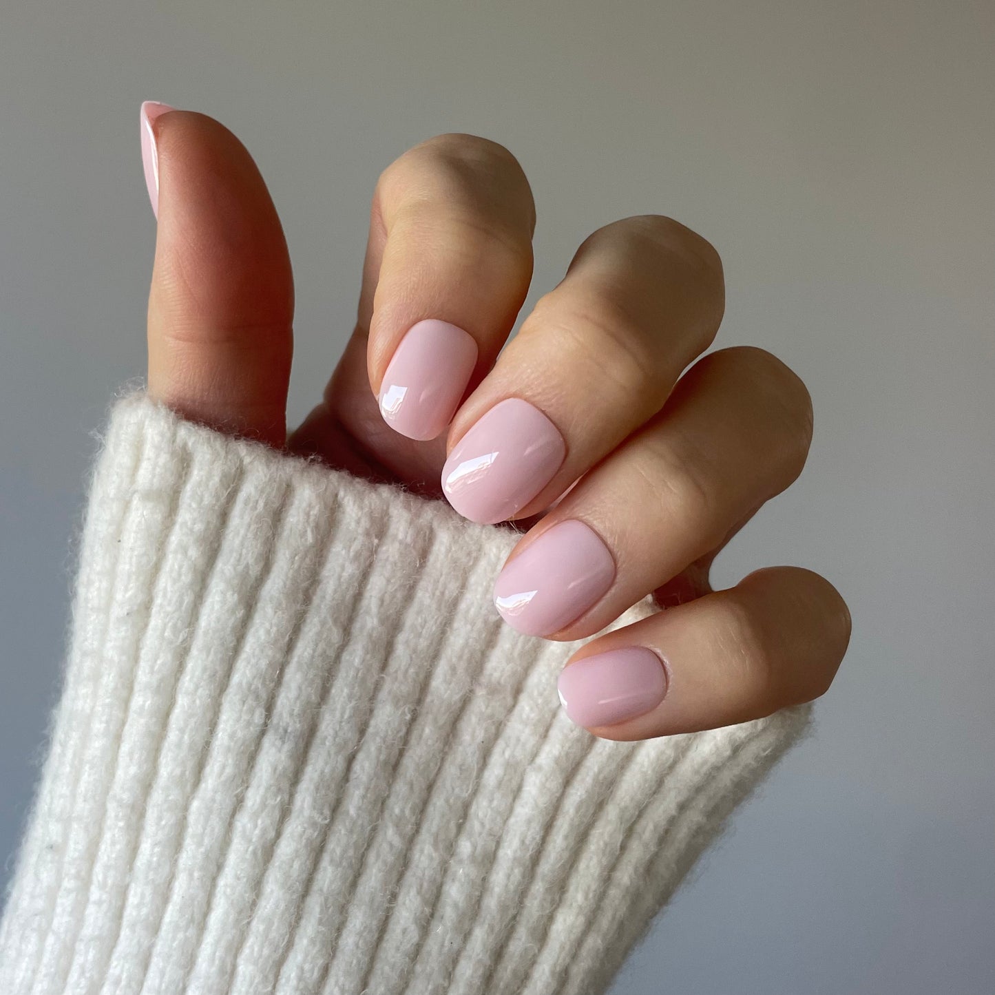 Womans hand with the palest pink removable and reusable professional salon quallity Candy Claws in pillow talk extra-short style